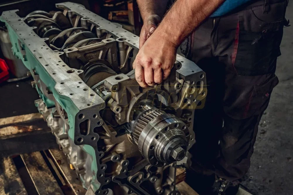 Inverted diesel engine block with crankshaft and gear during an overhaul