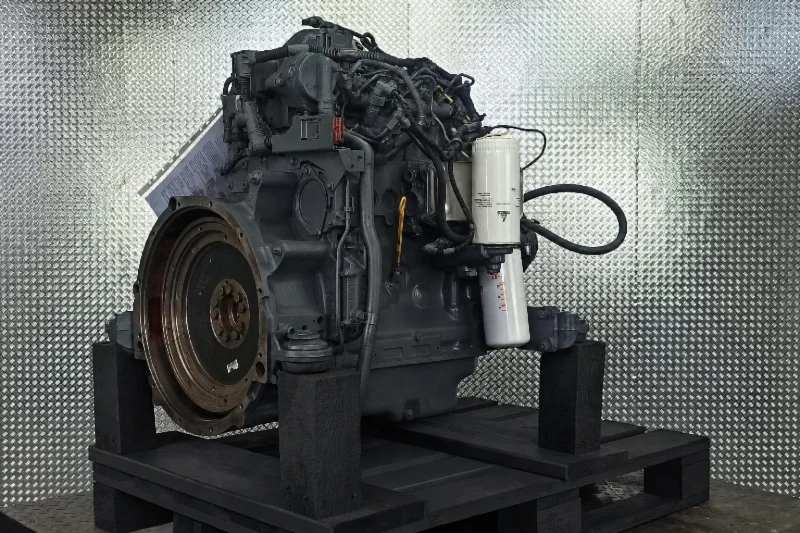 Remanufactured six-cylinder diesel engine on a pallet in a parts warehouse with shelving