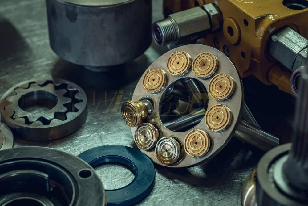 Piston pump parts: retaining plate with pistons in brass slippers, gear and sealing ring on a workbench