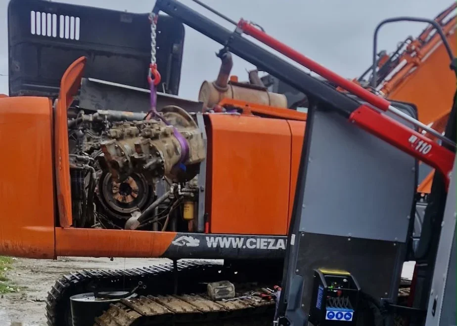 Hitachi ZX350LC-3 hydraulic pump being lifted out of the machine compartment on a sling from the service van crane