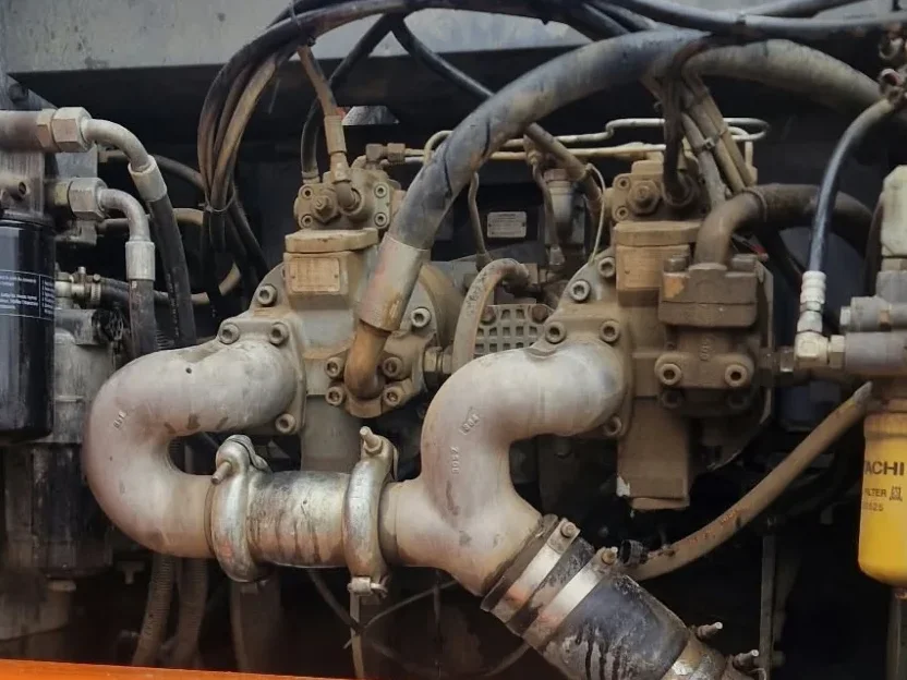 Pump compartment of a Hitachi ZX350LC-3 with hydraulic pump suction pipes, drum for drained oil below