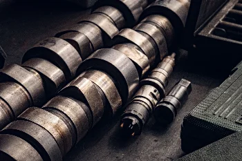 Diesel engine camshafts and fuel injectors laid out on a workshop bench
