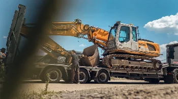 Liebherr 906 crawler excavator loaded on a low-loader trailer for transport