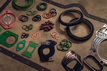 Engine gasket set: head and oil pan gaskets, O-rings, copper washers and valve stem seals on a concrete floor