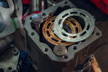 Open hydraulic pump housing with bronze valve plate and port plate during overhaul