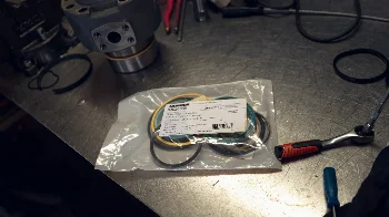 Liebherr seal kit in a bag on a workbench next to a ratchet and a hydraulic cylinder part