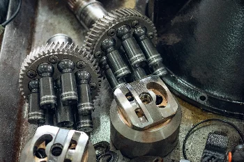 Disassembled hydraulic unit: cylinder blocks with gears, pistons and valve plates on a workshop bench