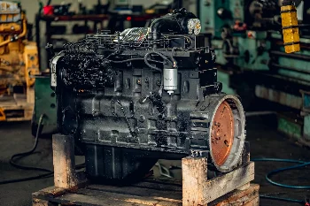 Reconditioned six-cylinder diesel engine with injection pump on a pallet in a workshop hall
