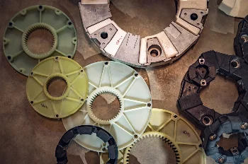 Flexible couplings and drive plates with internal gearing laid out on a workshop table