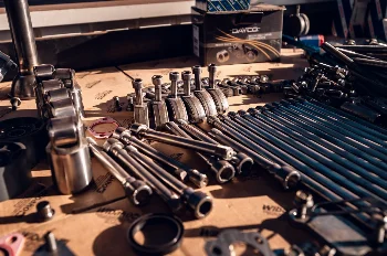Engine parts laid out for assembly: head bolts, rocker arms, tappets and a DAYCO box